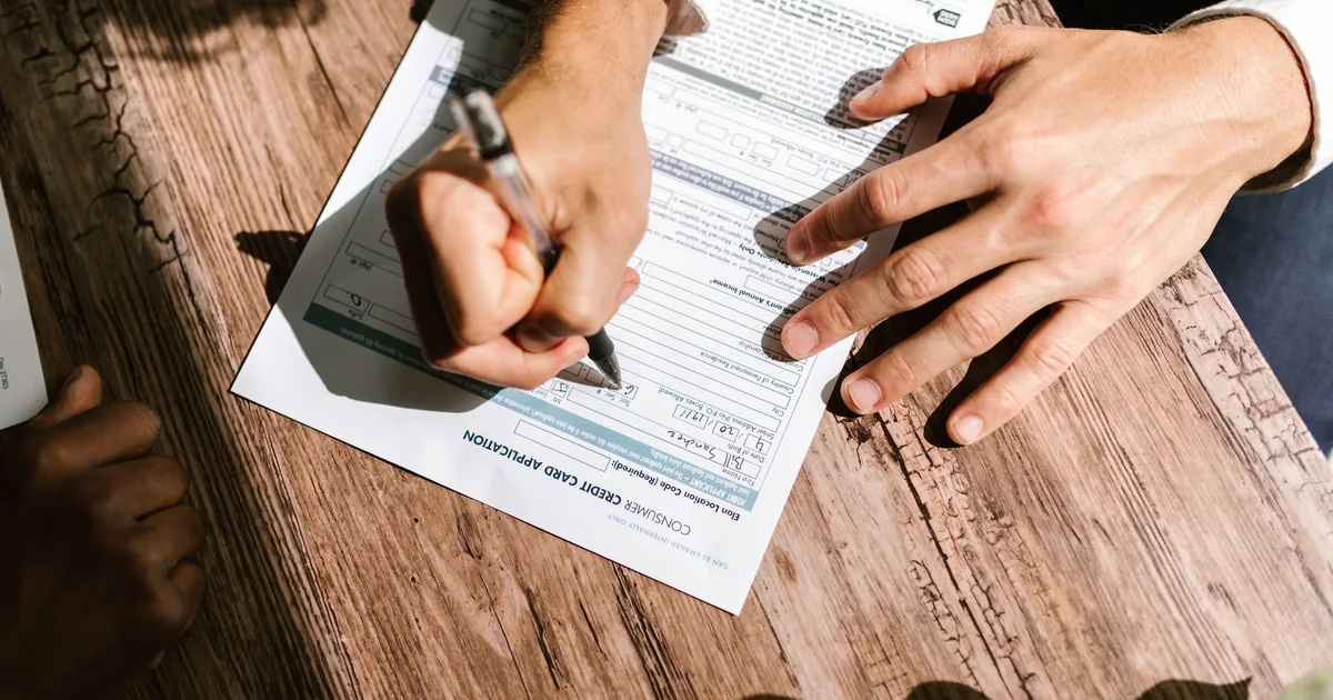 Person filling out a consumer credit card application form